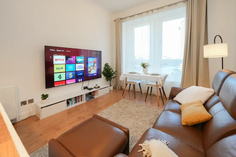 Modern Scandinavian-style lounge at Saltcoats Central with dining table and large smart TV